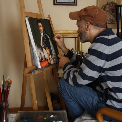 Painter in the studio — working on fine details of an oil painting